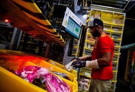 A worker selects and packs items during Cyber Monday at the Amazon fulfilment centre in Robbinsville Township in New Jersey, U.S., November 28, 2022.