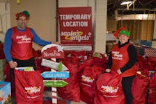 Kenny Zakem, left, and Colleen McCabe gear up for the annual Santa’s Angels charity giveaway. Santa’s Angels is in a temporary location inside Royalty Crossing but is looking for a new home. Dave Stewart • The Guardian