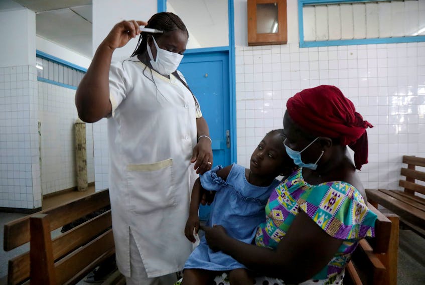 A nurse prepares to take the temperature of a child with malaria at Marcory General Hospital in Abidjan, Ivory Coast October 7, 2021.