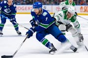  Dallas Stars’ Ty Dellandrea (10) grabs Vancouver Canucks’ Carson Soucy (7) as he skates with the puck during the first period of an NHL hockey game in Vancouver, on Saturday, Nov. 4, 2023.