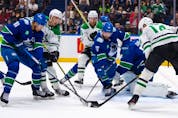 Vancouver Canucks' Dakota Joshua (81) and Filip Hronek (17) battle for the puck with Dallas Stars' Jason Robertson (21), Joe Pavelski (16), and Jamie Benn (14) during the first period of an NHL hockey game in Vancouver, on Saturday, Nov. 4, 2023.