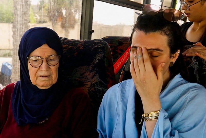 Suzan Beseiso, a Palestinian holding a U.S. passport, reacts while sitting next to her grandmother in a vehicle, as she waits for permission to leave Gaza, amid the ongoing conflict between Israel and Palestinian Islamist group Hamas, at the Rafah border crossing with Egypt, in Rafah in the southern Gaza Strip, November 2, 2023.