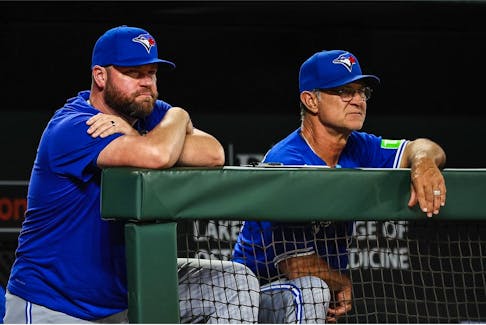 Blue Jays manager John Schneider (left) and bench coach Don Mattingly watch the play against the Baltimore Orioles.