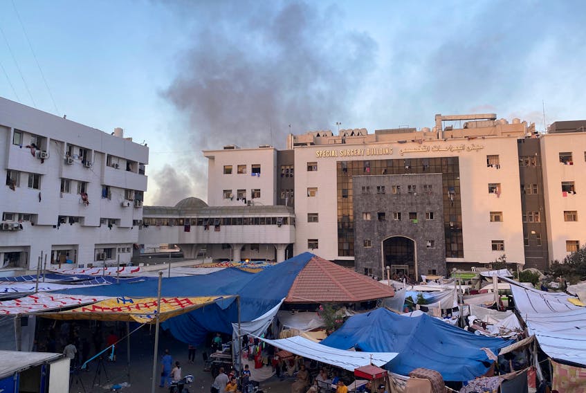 Smoke rises as displaced Palestinians take shelter at Al Shifa hospital, amid the ongoing conflict between Hamas and Israel, in Gaza City, November 8, 2023.