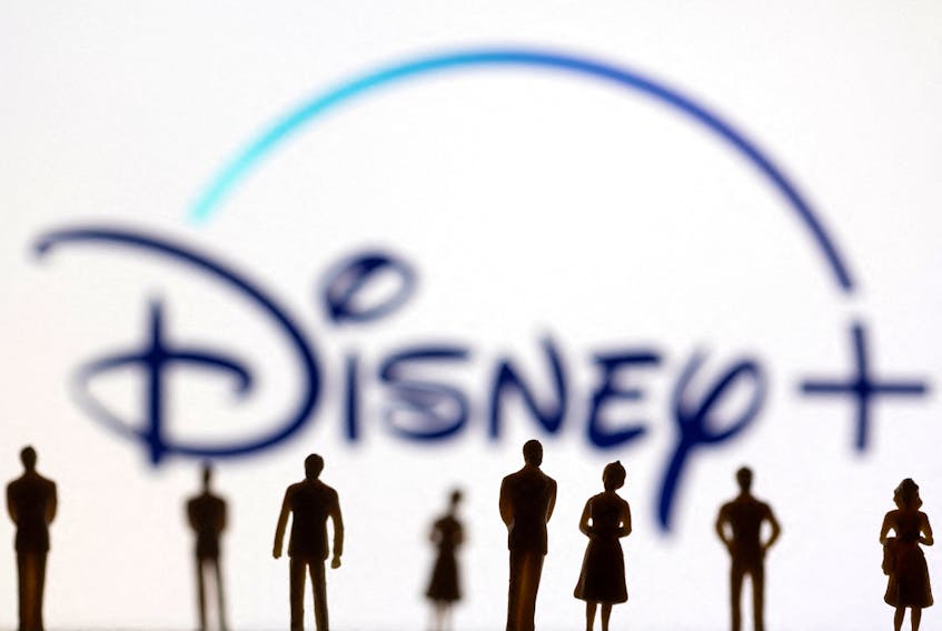 Toy figures of people are seen in front of the displayed Disney + logo, in this illustration taken January 20, 2022.