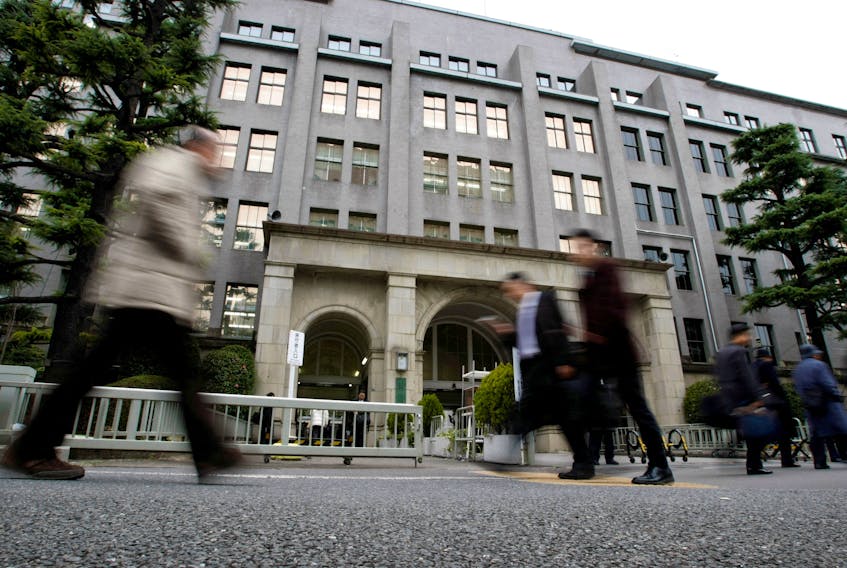 Pedestrians walk past the Finance Ministry building in Tokyo March 13, 2009. 