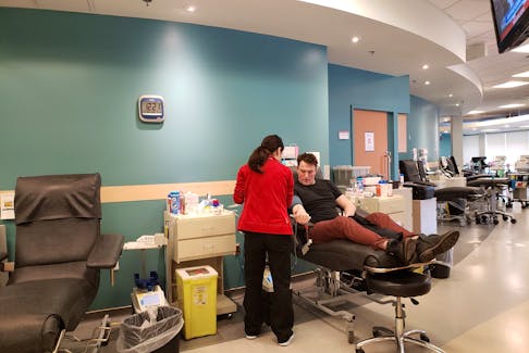 A man donates blood in the relatively empty donor area at the Canadian Blood Services centre on Bayers Road in Halifax.