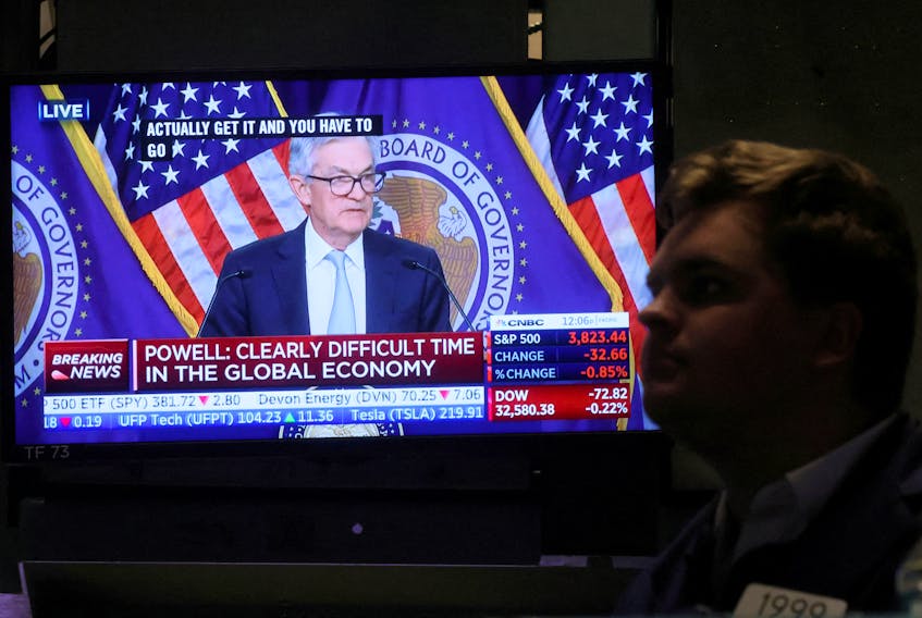 A screen displays Federal Reserve Chair Jerome Powell speaking as a trader works on the floor of the New York Stock Exchange (NYSE) in New York City, U.S., November 2, 2022. 