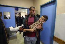 A Palestinian boy wounded in an Israeli strike is carried, after a temporary truce between Hamas and Israel expired, at Nasser hospital in Khan Younis in the southern Gaza Strip, December 1, 2023.