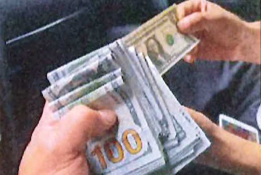 An undercover U.S. law enforcement officer is handed $15,000, described by the U.S. Department of Justice as the advance cash payment, by an associate of Nikhil Gupta, who was charged with orchestrating the attempted murder of a Sikh separtist, in a car in the Manhattan borough of New York City, U.S. June 9, 2023, in a photograph contained in an indictment. U.S. District Court/SDNY/Handout via