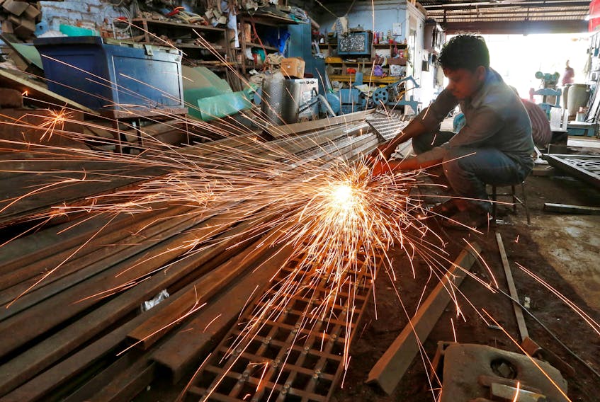 A worker grinds a metal gate inside a household furniture manufacturing factory in Ahmedabad, India, July 1, 2016.