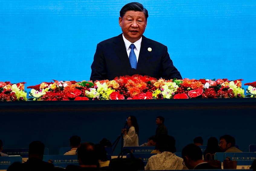 Journalists watch a giant screen broadcasting footage of Chinese President Xi Jinping speaking at the opening ceremony of the Third Belt and Road Forum (BRF), at the media centre in Beijing, China October 18, 2023.