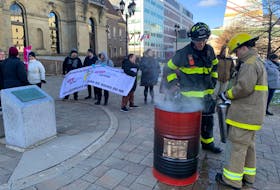 Firefighters douse flames on the legislature grounds that were set by protesting labour activists, who burned their collective agreements on Wednesday. - Andrew Waugh, Brunswick News, via Local Journalism Initiative