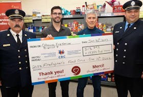 Sector Fire Chief Larry Roy (left) and Lt. Denis Charbonneau (right) from Ottawa Fire Services present a cheque to Chad Chartrand (second to the left), community &amp; fund development co-ordinator, and Luc Ouellette, executive director, of the Orleans-Cumberland Community Resource Centre in Orleans on Jan. 30, 2023. 