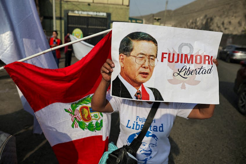 A follower of Peruvian President Alberto Fujimori holding a placard stands outside a prison, after a top court reinstated the pardon of Fujimori, in Lima, Peru, November 29, 2023.