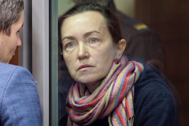Russian-American journalist for Radio Free Europe/Radio Liberty (RFE/RL) Alsu Kurmasheva, who is in custody after she was accused of violating Russia's law on foreign agents, listens to a lawyer while standing inside an enclosure for defendants as she attends a court hearing in Kazan, Russia, December 1, 2023.