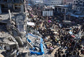 Palestinians shop in an open-air market among the ruins of houses and buildings destroyed in Israeli strikes during the conflict, amid a temporary truce between Hamas and Israel, in Nuseirat refugee camp in the central Gaza Strip November 30, 2023.