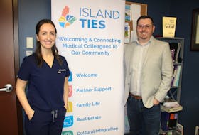 From left, Dr. Meaghan Keating in her office with Bryan Pratt on Wednesday. They are standing next to a sign which promotes the non-profit group they have started called Island Ties. The group aims to help with new doctor retention and is looking for volunteers. NICOLE SULLIVAN/CAPE BRETON POST