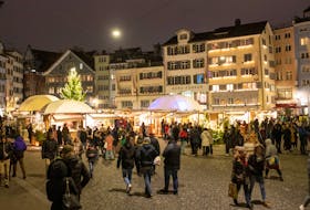 People walk at the Christmas market at the Muensterhof square in Zurich, Switzerland, December 3, 2022.