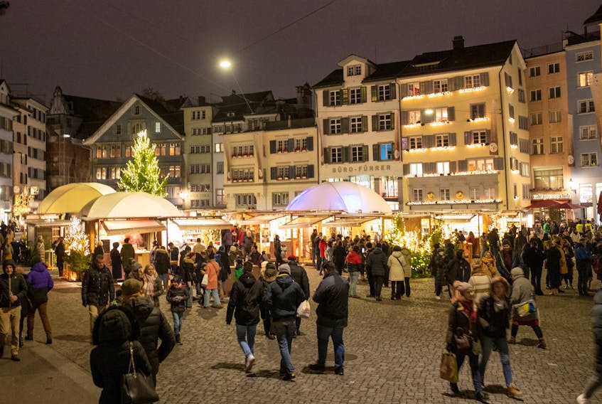 People walk at the Christmas market at the Muensterhof square in Zurich, Switzerland, December 3, 2022.