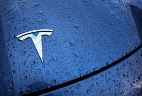 The logo of a Tesla electric vehicle is placed on a car outside a dealership in Drogenbos, Belgium November 25, 2023.