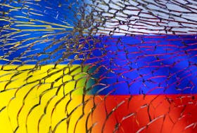 Ukraine and Russian flags are seen through broken glass in this illustration taken March 1, 2022.