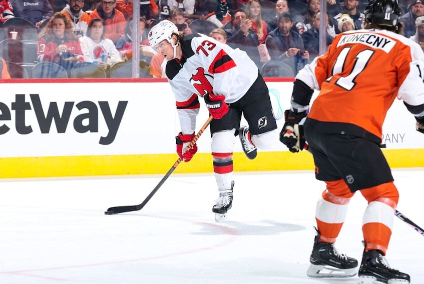 PHILADELPHIA, PENNSYLVANIA - NOVEMBER 30: Tyler Toffoli #73 of the New Jersey Devils skates with the puck past Travis Konecny #11 of the Philadelphia Flyers during the first period at the Wells Fargo Center on November 30, 2023 in Philadelphia, Pennsylvania.