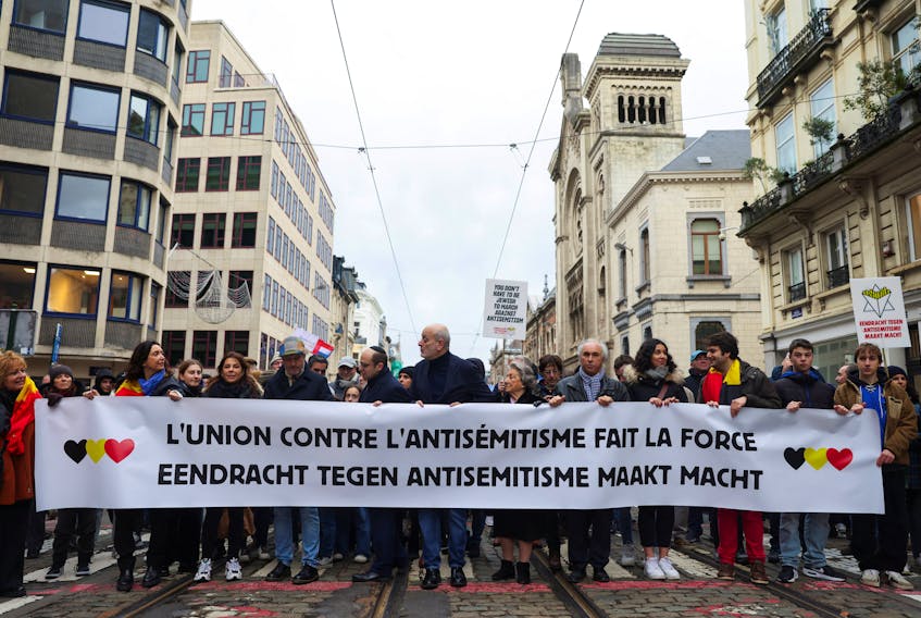 People hold a banner reading "Union against antisemitism makes strength" during a demonstration against antisemitism, amid the ongoing conflict between Israel and Palestinian Islamist group Hamas, in Brussels, Belgium December 10, 2023.