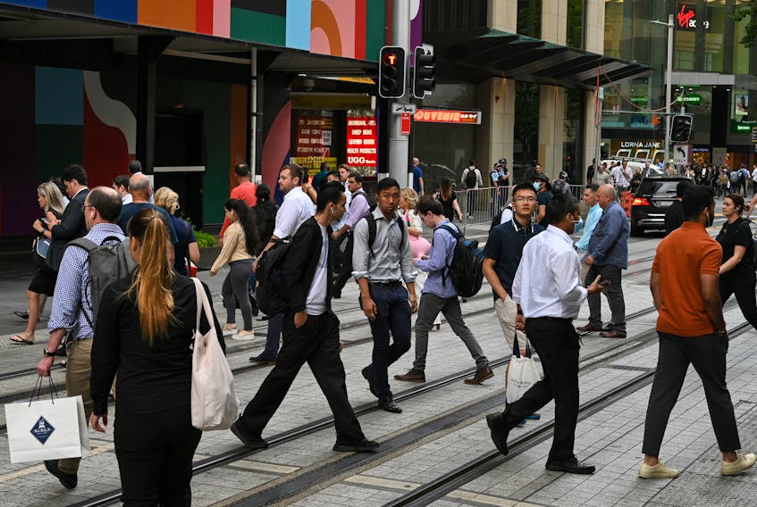 File photo: People cross a street in the city centre following further easing of coronavirus disease (COVID-19) restrictions in Sydney, Australia, December 10, 2020. 