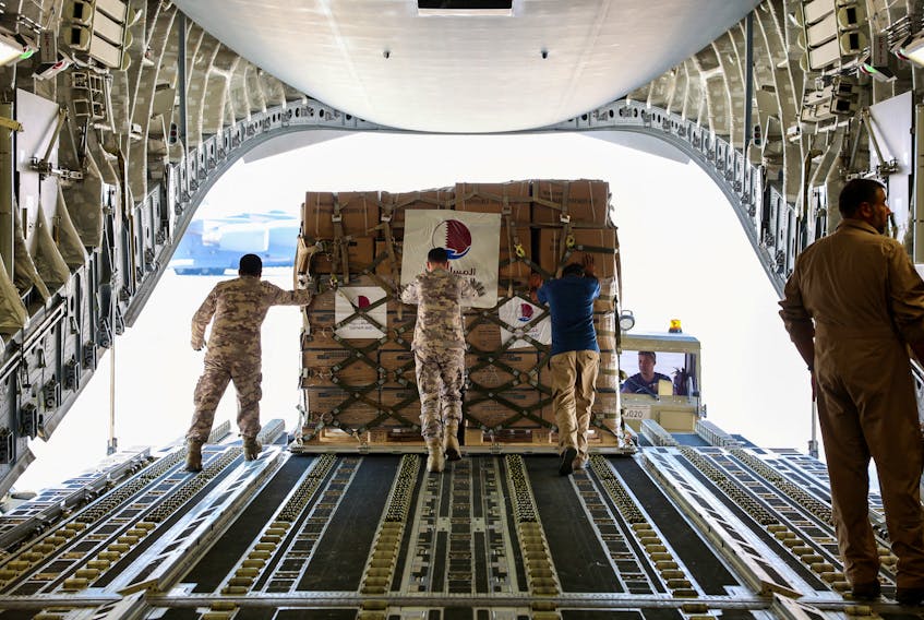 Qatari Amiri Air Force crew load food and medical aid to their cargo plane from the Qatar Fund for Development headed to Egypt for Gaza, at Al Udeid Air Base, Doha, Qatar, October 16, 2023. Qatar News Agency/Handout via
