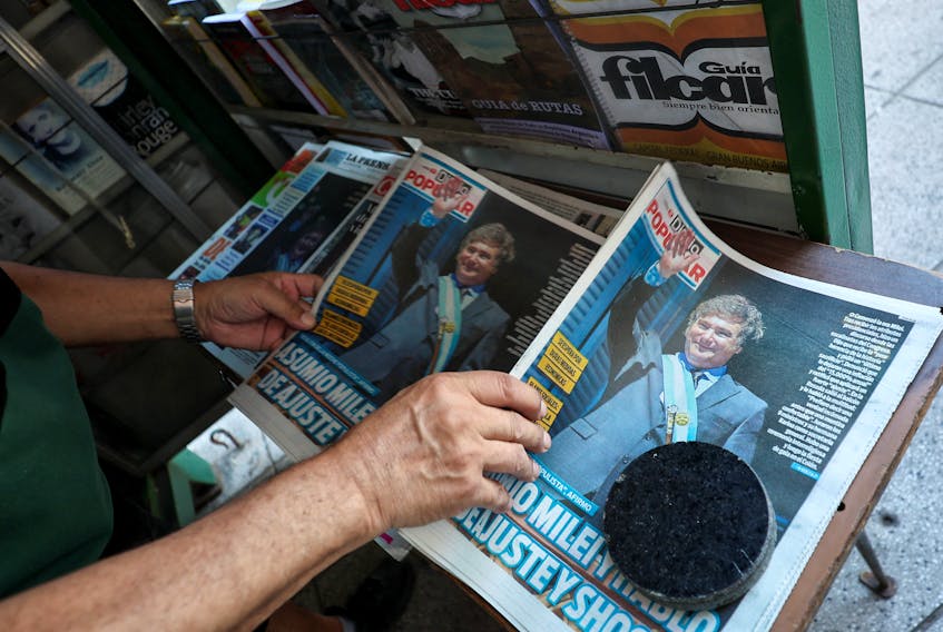 A kiosk owner rearranges newspapers, one day after the inauguration of Argentina's President Javier Milei and his Vice President Victoria Villarruel, in Buenos Aires, Argentina, December 11, 2023.