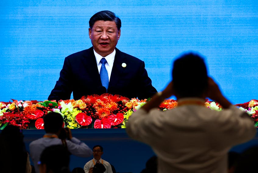 Journalists watch a giant screen broadcasting footage of Chinese President Xi Jinping speaking at the opening ceremony of the Third Belt and Road Forum (BRF), at the media centre in Beijing, October 18, 2023.