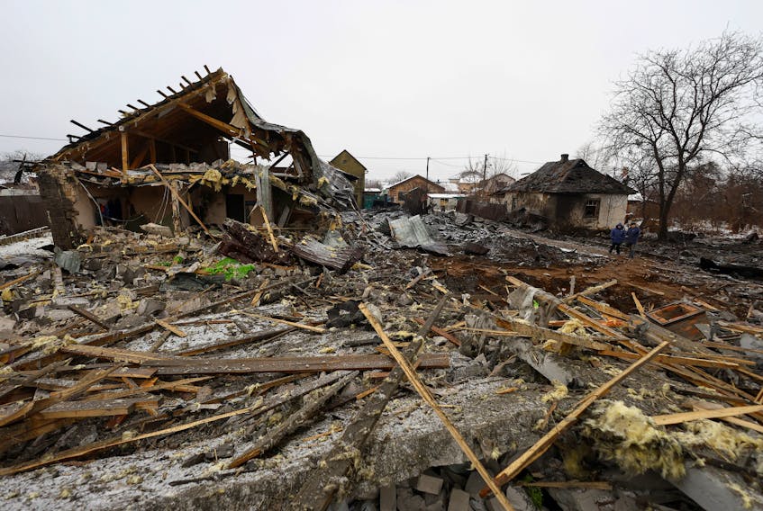 Local residents stand at a site of residential buildings, heavily damaged by a Russian missile strike, amid Russia's attack on Ukraine, in Kyiv, Ukraine December 11, 2023.