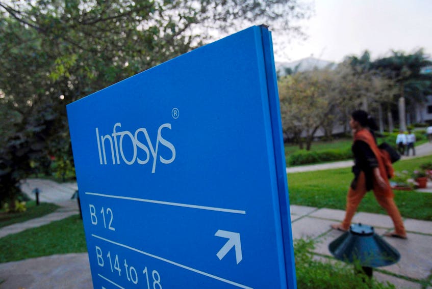 An employee walks past a signage board in the Infosys campus at the Electronics City IT district in Bangalore, February 28, 2012.