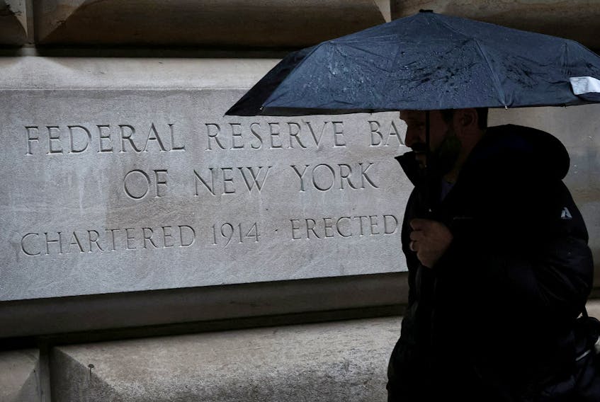 A man passes by the Federal Reserve Bank of New York in New York City, U.S., March 13, 2023.