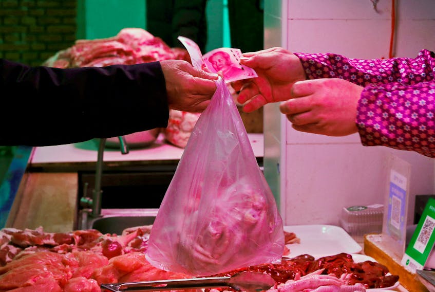 A man pays for meat at a market in Beijing, China January 11, 2021.
