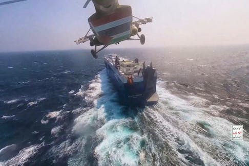 Houthi military helicopter flies over the Galaxy Leader cargo ship in the Red Sea in this photo released November 20, 2023. Houthi Military Media/Handout via REUTERS