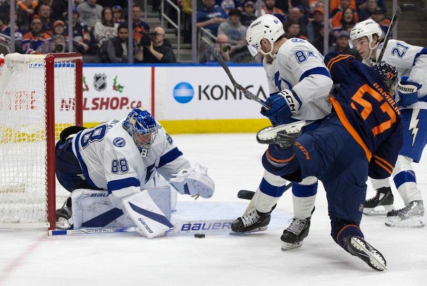  The Edmonton Oilers’ James Hamblin (57) battles the Tampa Bay Lightning’s Tanner Jeannot (84) as goalie Andrei Vasilevskiy (88) makes the save during third period NHL action at Rogers Place, in Edmonton Thursday Dec. 14, 2023. The Lightning won 7-4.