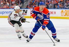 Chicago Blackhawks forward Connor Bedard (98) tries to knock the puck away from Connor McDavid (97) of the Edmonton Oilers during a recent game at Rogers Place. Sports columnist Lyle Richardson says a better supporting cast is just the gift that Bedard, the top NHL rookie so far this season, needs to find under his Christmas tree. Perry Nelson • USA TODAY Sports