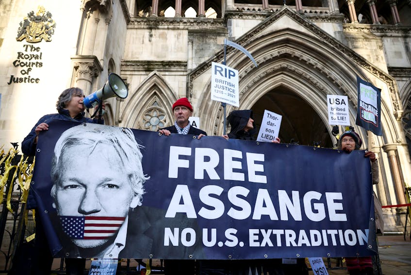 Supporters of Julian Assange display signs and a banner, outside the Royal Courts of Justice in London, Britain December 10, 2021.
