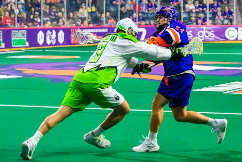 Clarke Petterson of the Halifax Thunderbirds fires a shot while being checked by Saskatchewan Rush defender Bobby Kidd III during the National Lacrosse League season opener Friday night at Scotiabank Centre. Petterson had eight points in a 17-12 Halifax win. - National Lacrosse League