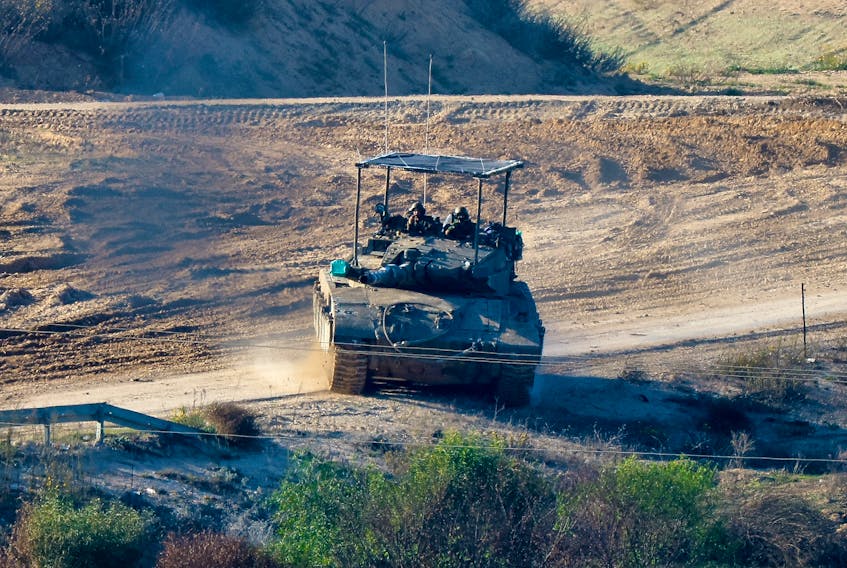 Israeli soldiers operate a tank near Gaza, after a temporary truce between Israel and the Palestinian Islamist group Hamas expired, as seen from southern Israel, December 2, 2023.