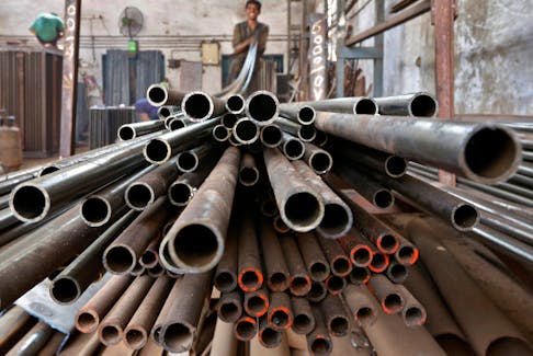 A worker stacks steel pipes in the western Indian city of Ahmedabad November 4, 2014.