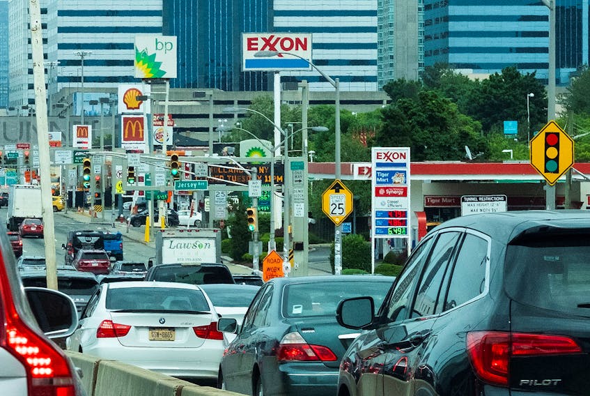 People drive their cars near Exxon and BP gas stations at the exit of the Holland Tunnel during the start of the Memorial Day weekend, under rising gas prices and record inflation, in Newport, New Jersey, U.S., May 27, 2022. 