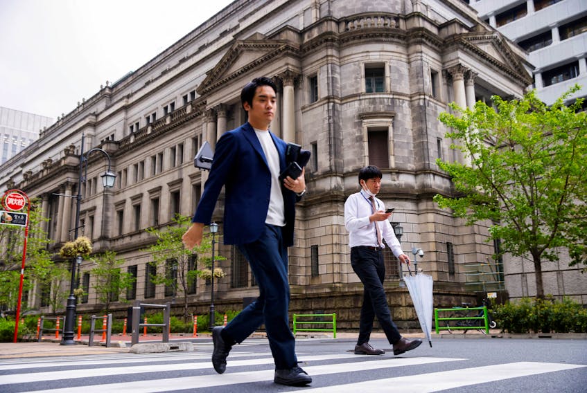 People walk in front of the bank of Japan building in Tokyo, Japan, April 7, 2023.