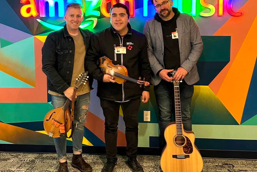 From left, Ryan Roberts, Morgan Toney and Keith Mullins stand in front of the Amazon Music logo in the company's 47th floor office in Scotia Plaza in Toronto. CONTRIBUTED/MORGAN TONEY