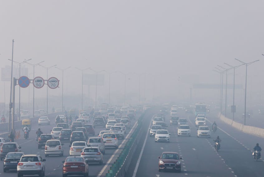 Traffic moves along a highway shrouded in heavy smog in New Delhi, India, December 26, 2023.