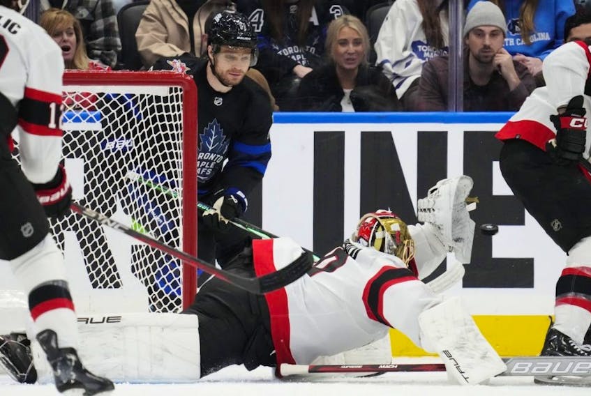  Senators goaltender Joonas Korpisalo makes a spectacular save as Toronto Maple Leafs’ Max Domi looks on during Wednesday’s win. Frank Gunn/The Canadian Press