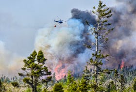 A Department of Natural Resources and Renewables helicopter releases water over a wildfire burning out of control in the Barrington/Clyde River region of Shelburne County on Sunday, May 28, 2023. FRANKIE CROWELL PHOTO