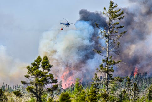 A Department of Natural Resources and Renewables helicopter releases water over a wildfire burning out of control in the Barrington/Clyde River region of Shelburne County on Sunday, May 28, 2023. FRANKIE CROWELL PHOTO